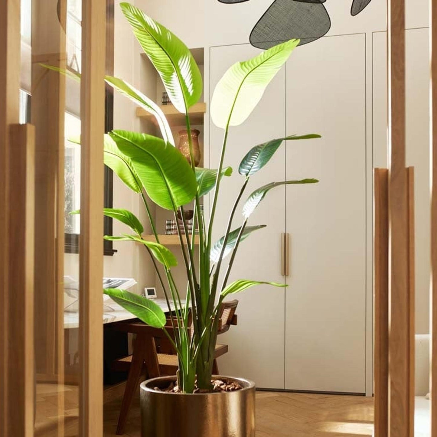 Strelitzia Nicolai kunstplant van 180 cm hoog in zwarte pot, met realistische bananenbladachtige bladeren in diepgroen. Plantsome
